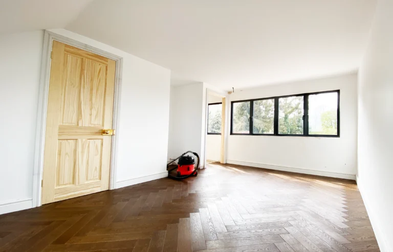 Finished loft room with black-framed dormer windows and herringbone flooring