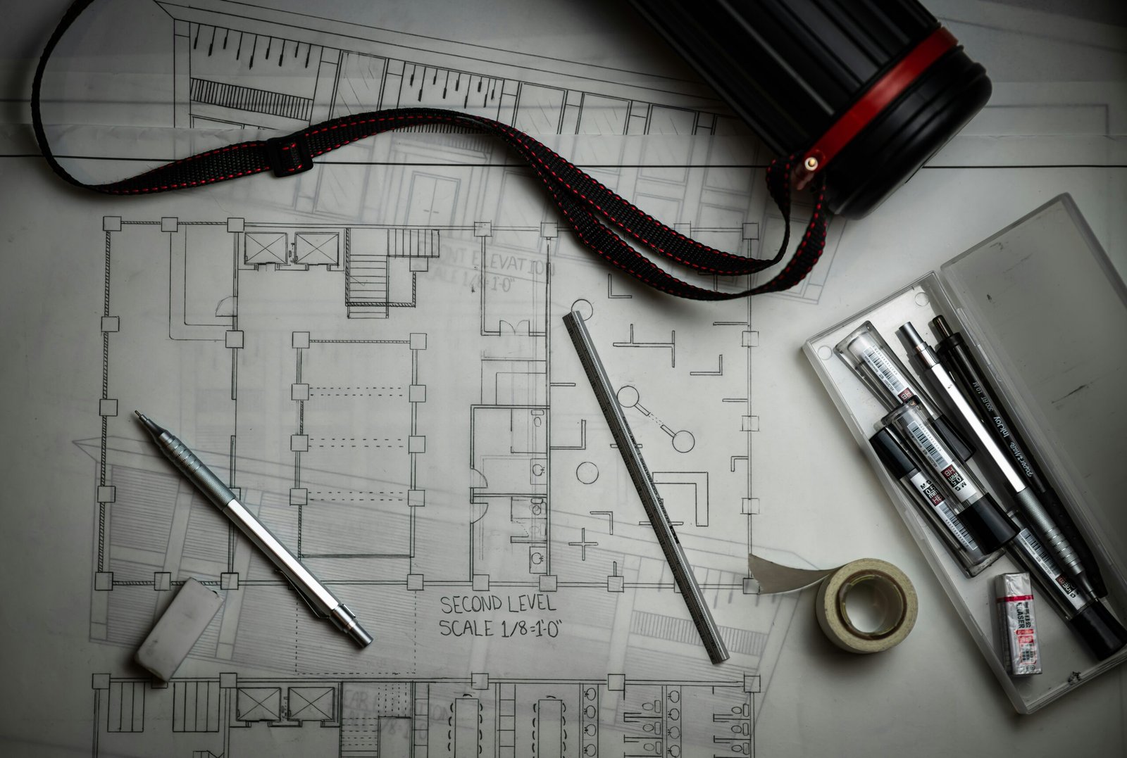Architectural plans with drawing tools and pencils